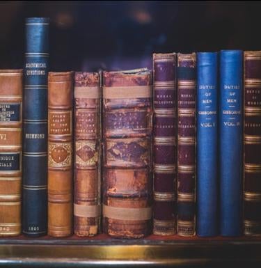 A shelf containing thick, older books
