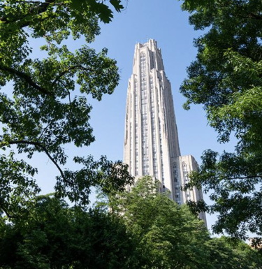 View of the Cathedral of Learning through blooming spring trees.